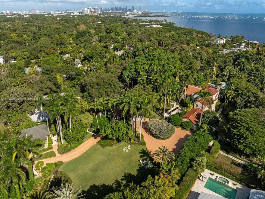 Coconut Grove De Garmo architectural masterpiece on over 2 acres of private dramatically lit botanic gardens has captivated hearts & headlines for nearly a century. Striking Spanish-style estate seamlessly blends old world charm with modern sophistication. Ground level boasts a grand entrance, distinctive indoor/outdoor veranda, stately vaulted living room, library & formal dining room. 2nd floor offers 4 spacious bedrooms each with en-suite baths and balcony overlooking living room. 3rd story includes versatile living space & terrace. Detached from primary residence: 2 large guest apts in the gatehouse, 60ft tiled pool complemented by spacious cabana. This exclusive paradise also features an orchid house, serene waterfall & areas for relaxation. This home is a sanctuary and a work of art.