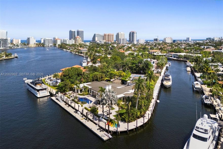 Welcome to 2300 Aqua Vista Boulevard, a truly extraordinary waterfront estate in the prestigious Seven Isles neighborhood. Perfectly set on a rare 1.14 acre point lot with 550 feet of deep-water frontage along the Barcelona Canal, this property is a dream for mega yacht owners seeking direct ocean access. The reimagined estate spans 8,130 square feet of luxurious living, offering 7 bedrooms and 7.5 bathrooms, blending timeless elegance with modern sophistication. Highlights include a brand-new metal roof with a 100 year warranty, hurricane rated impact windows and doors, and soaring high ceilings. Designed for grand scale entertaining, the home boasts a chef’s kitchen and prep kitchen with custom cabinetry, backlit Crystallo, premium appliances, and an expansive pantry, plus a chic bar and lounge with water views. The first floor primary suite features coffered ceilings, pool access, a spa inspired bath, and a custom walk in closet. Outdoors, the estate becomes a private resort with a tennis court that doubles as basketball and pickleball courts, a tiled pool with new equipment, a new seawall and concrete dock, and 550 feet of premier dockage for multiple vessels. Lush tropical landscaping and lighting create a stunning ambiance day and night. Additional enhancements include an Allini water purification system, renovated garage, and advanced security system. 2300 Aqua Vista blvd is a rare waterfront compound and one of Fort Lauderdale’s most exceptional offerings.
