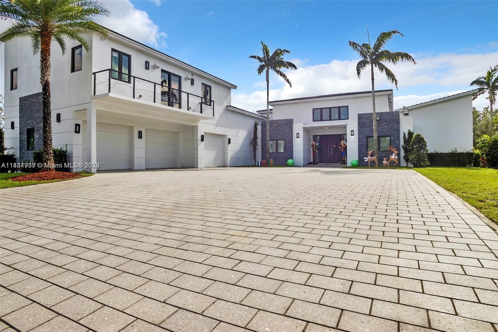 Modern masterpiece on expansive grounds, boasting soaring 20-ft ceilings, sleek porcelain floors, and a chef’s kitchen with custom cabinetry and quartz counters. Six spacious bedrooms each offer private ensuite baths and custom walk-in closets. The lavish primary suite features a serene sitting area, dual walk-in closets (his and hers), and a luxe glam room with built-ins for shoes, handbags, and makeup. A private elevator provides access to the second level, where you’ll find a stunning home theater, bar, and kitchen. Outdoors, indulge in resort-style living with a saltwater pool, spa, summer kitchen, covered terrace, and an impressive driveway with a 3-car garage. Smart, energy-efficient, and built for ultimate contemporary living.