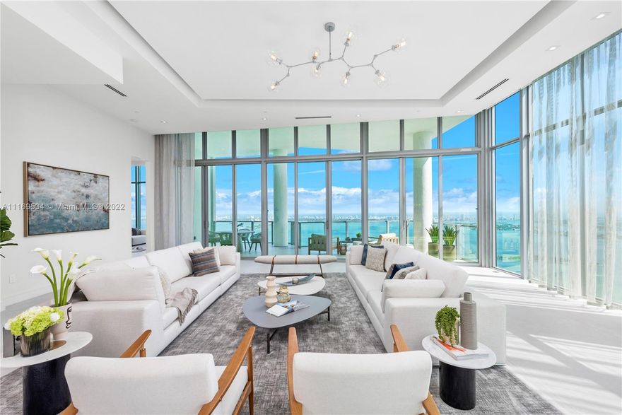 Enter this one-of-a-kind lower penthouse and be prepared to be awestruck. Enjoy wraparound views of Biscayne Bay and Miami Beach from soaring 15-ft floor-to-ceiling windows that welcome natural light throughout the entire penthouse. Special features include 60” x 60” tile, custom ceiling lighting plan, massive master bedroom with in-suite lounge, 4 guest suites + 1 staff room, a west-facing den, outdoor summer kitchen and 4 parking spaces. Located in the heart of all that is trending in Miami within a 5-10 minute drive to Design District, Wynwood, Downtown, Brickell and South Beach.