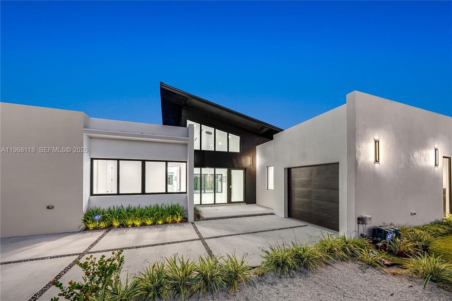 Indulge in elevated modern living within this striking 3,200-square-foot concrete masterpiece, defined by dramatic 22-foot ceilings and architectural sophistication. Thoughtfully designed for both comfort and grandeur, the residence features four generously proportioned bedrooms, three impeccably appointed bathrooms, and expansive living spaces bathed in natural light. At the heart of the home, a chef-inspired gourmet kitchen showcases bespoke wood cabinetry and exquisite Taj Mahal quartz countertops—an artful fusion of refined beauty and enduring performance.
Seamlessly blending indoor and outdoor living, the private terrace reveals a sparkling pool, creating a serene retreat ideal for intimate relaxation or elegant entertaining. A secure garage enhances both convenience and peace of mind. A rare offering that embodies timeless elegance, exceptional craftsmanship, and uncompromising exclusivity.