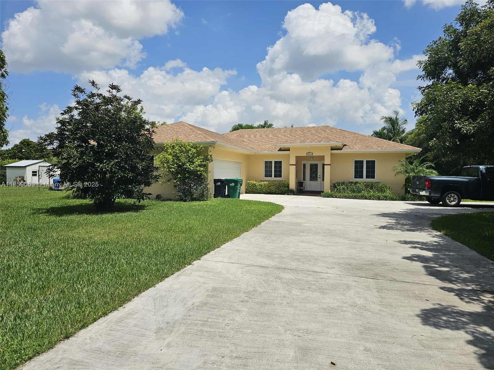 Affordable Redland living on a fenced corner lot with room for a pool and RV/boat parking. Custom-built 3BR/2BA split plan (2002) with a brand-new roof and vaulted ceilings. Two-car garage, two gated entries, and wide side yards. Common areas are tiled. The eat-in kitchen offers an island plus generous cabinet and pantry storage. A dedicated laundry room adds convenience. An open back patio extends the living space outdoors; lychee trees are in the front and along the sides. The private primary suite includes a jetted/Jacuzzi tub, separate shower, vanity, and a spacious walk-in closet. Quiet setting near farms, parks, and major routes.