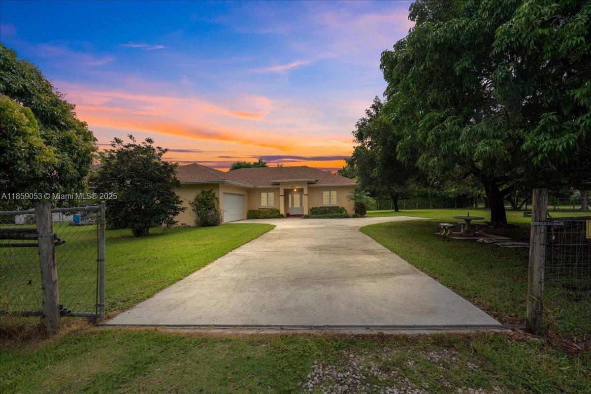 Affordable Redland living on a fenced corner lot with room for a pool and RV/boat parking. Custom-built 3BR/2BA split plan (2002) with a brand-new roof and vaulted ceilings. Two-car garage, two gated entries, and wide side yards. Common areas are tiled. The eat-in kitchen offers an island plus generous cabinet and pantry storage. A dedicated laundry room adds convenience. An open back patio extends the living space outdoors; lychee trees are in the front and along the sides. The private primary suite includes a jetted/Jacuzzi tub, separate shower, vanity, and a spacious walk-in closet. Quiet setting near farms, parks, and major routes.