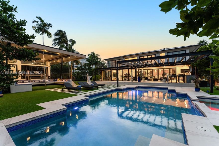 Set on a rare 17,200 SF double lot in Miami Beach’s coveted Lakeview neighborhood, this 2022 custom residence is a modern sanctuary of scale, design, and privacy. The main home offers more than 5,500 interior square feet with four ensuite bedrooms and five and a half baths, an executive office, and expansive living spaces finished in white oak and marble flooring. At the center of the home is a refined chef’s kitchen with Wolf and Sub Zero appliances, dual islands, a full butler’s pantry, and a climate controlled, full height wine display. Soaring glass doors open to an oversized covered terrace and one of the best outdoor programs in Miami Beach, featuring a large heated pool, integrated hot tub, summer kitchen, and lush tropical landscaping. A separate guest house with one and a half baths provides a private retreat for visitors, extended stays, or the perfect wellness retreat. Fully automated with a Control4 system, the estate offers a seamless blend of modern comfort and thoughtful design. Minutes from premier dining, shopping, and Miami Beach amenities, this Lakeview residence embodies the ideal balance of luxury, livability, and tranquility.