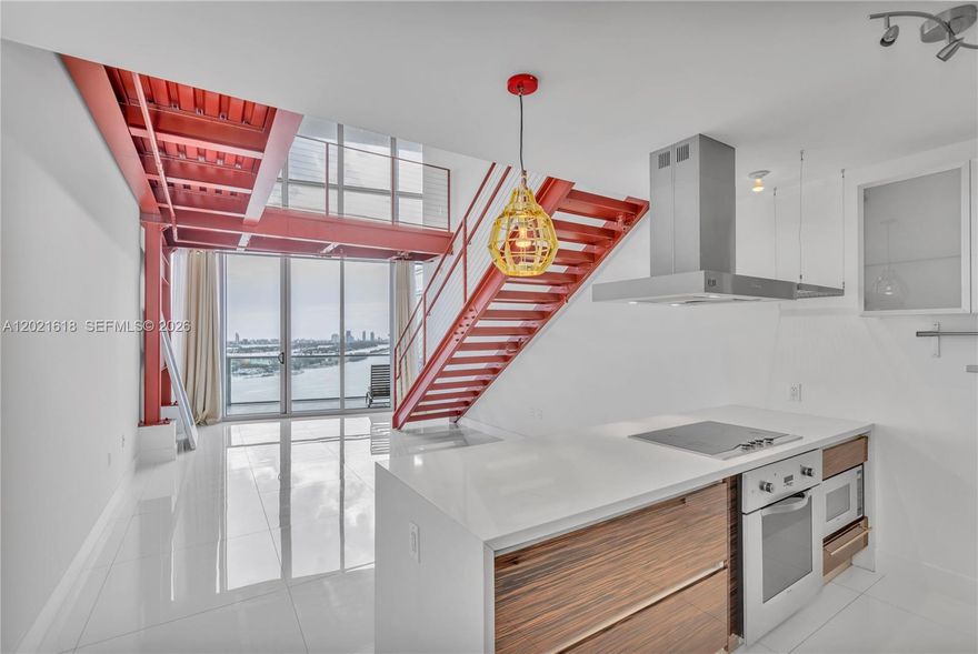 Amazing oceanfront views. This unique loft residence offers 200+ additional SqFt compared to other units in the same line, bringing the total living area to over 1,900 SqFt. A modern steel and wood mezzanine creates the perfect library or office space. The staircase has been redesigned and relocated to allow for an oversized primary closet, larger than those in comparable units. The converted den functions as a 2nd bedroom with a walk-in closet. Additional features: large laundry room, exposed brick accent wall, assigned parking, and extra storage in the building. Located directly across from the Pérez Art Museum and waterfront park. Just a 10-minute drive to South Beach, the Miami Design District, Brickell, and Miami International Airport. The building features an in-house hotel, spa, restaurant, and top-of-the-line amenities, including a basketball court. Freshly painted.