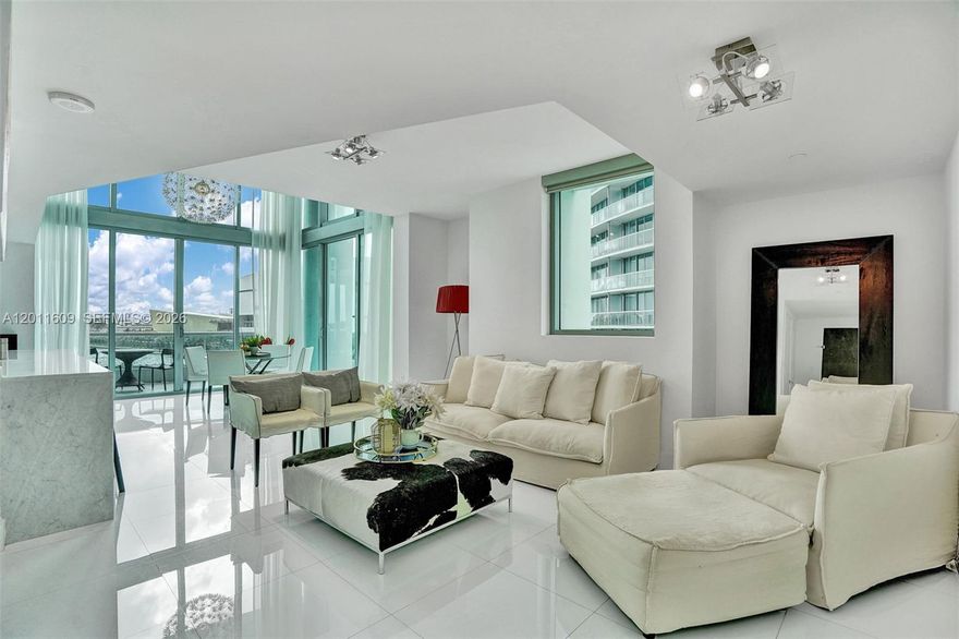 Commanding, unobstructed bay views set the tone for this fully furnished, bi-level corner townhouse, where dramatic 22-foot ceilings and expansive walls of glass create an impressive sense of volume and light throughout the main living area. The residence blends clean, modern design with high-end finishes, including sleek white glass porcelain flooring, top-of-the-line appliances, and custom-built closets that maximize both functionality and storage.

The open living and dining areas are designed for both everyday comfort and entertaining, seamlessly connected to the kitchen with premium appliances and refined cabinetry. The layout is exceptionally well planned, with one bedroom on the main level—ideal for guests or a home office—and two additional bedrooms upstairs, each with its own en-suite bathroom, ensuring privacy in every bedroom.

Both the primary suite and guest bedroom feature private balconies with direct water views, creating a true indoor-outdoor living experience. A rare offering combining scale, light, privacy, and refined finishes in a premier waterfront setting.