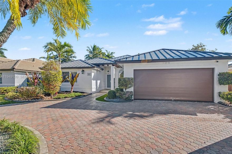 Beautiful 4 bdrm/ 3 bath home situated on a peaceful cul-de-sac. New metal roof, impact windows/doors, security cameras & full home diesel generator. Fantastic formal living & dining w/ volume ceilings, custom glass enclosed wine storage & built in saltwater fish tank. Modern kitchen features counter seating, Viking appliances & gas stove, opens to family rm ready for you to watch the game, w/ surround sound & projection system. Excellent split bdrm floorplan. Primary suite has dual closets, lovely bath /double sinks. Indoor laundry rm w/ storage. Fenced, tropically landscaped backyard ready for entertaining w/ covered patio/ lounge area, summer kitchen w/ BBQ, wine cooler & seating. 2 car garage w/ A/C & built-in storage, spacious attic, circular stamped paver driveway.