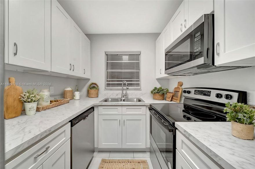 Beautifully remodeled first floor rear corner unit just steps from the pool and clubhouse. Enjoy the serene view from your screened porch. This beauty features tile floors, all new appliances and kitchen cabinets and counters, updated baths, freshly painted and an in-unit washer / dryer for added convenience. This adult community has new roofs, freshly paved parking lots and is on the hospital power grid, ensuring quick power restoration during storms. Close to major highways, beaches, downtown, FAU, shopping and essential services. Ideal for those seeking comfort, accessibility, and peace of mind in a well-kept, amenity-rich community. Take ahold of this opportunity as it will not last! Unit is currently vacant and has been virtually staged