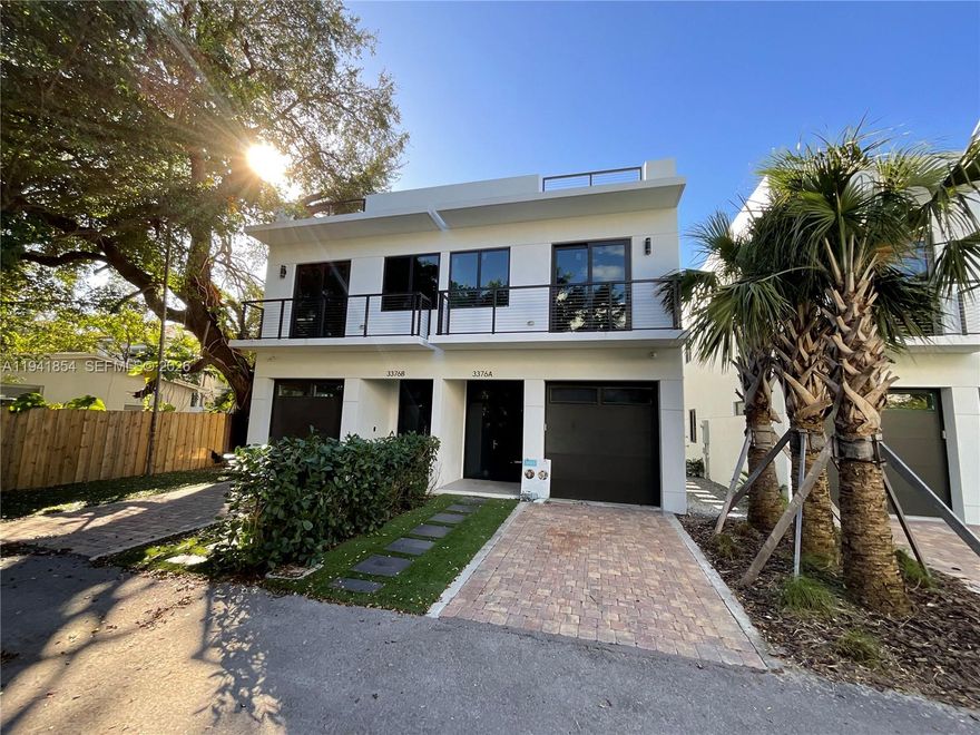 This beautifully designed, newer construction unfurnished luxury townhome is ideally located in the heart of Coconut Grove. Offering 3 bedrooms, 2 full baths, and 1 half bath across approximately 2,100 square feet, the home includes a one-car garage plus an additional private parking space.

A modern open-concept layout features sleek 36-inch white porcelain tile throughout all three levels. The residence includes two generously sized primary bedrooms, with the owner providing a custom build-out of the primary closet. The kitchen is ideal for cooking and entertaining, equipped with stainless steel appliances and seamless flow into the main living area.

Smart-home features include smart speaker connectivity, two security cameras, and a smart doorbell. Hurricane-impact windows and pocket sliding glass doors open to a private, gated backyard finished with low-maintenance artificial grass. Bathrooms showcase elegant white matte cabinetry.

The third floor offers a flexible office nook or fitness area and opens to a full-length tiled rooftop terrace with summer kitchen hookups—perfect for entertaining or unwinding. Just steps from downtown Coconut Grove, shops, and restaurants, this townhome delivers modern luxury and exceptional walkability.