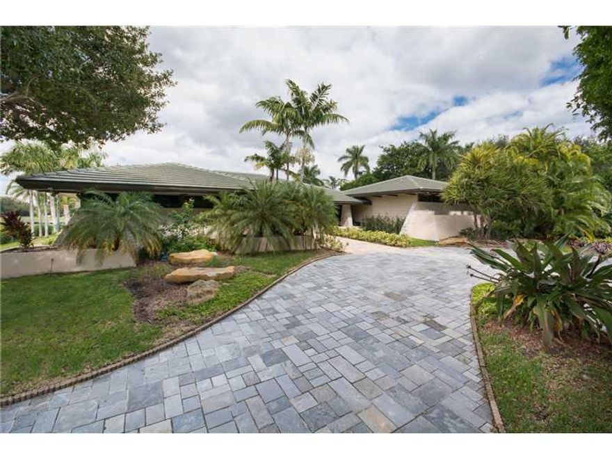 Located in one of Miami's premier waterfront communities this one-story residence boasts over 1.33 acres on a wide canal unencumbered by bridges. Over 9200 adj. sq. ft. of luxurious interiors w/ an exquisite paneled library, open formal areas, gorgeous wo od floors in the living room, volume ceilings, master suite w/sitting room, his & hers baths, walk-in closets & exercise room, island kitchen w/granite countertops & butler's pantry, swimming pool, lighted tennis court & 2-car garage. Re-do or build new.