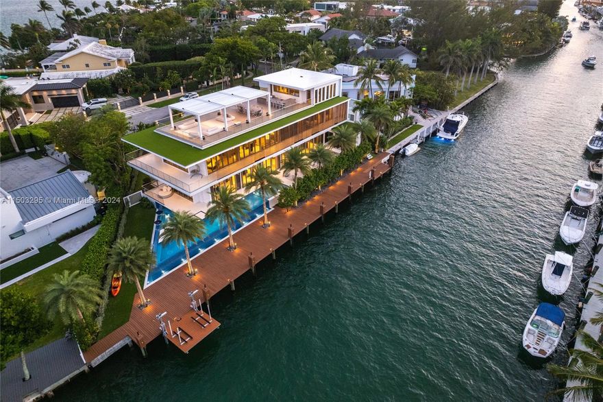 This  6-bed, 8-bath waterfront home offers 163 ft  2,000 sq ft deck. Built in 2023, barely-lived in , it comes equipped with smart home technology, astonishing  views, and luxury amenities like a jet ski lift, steel roof rooftop deck, and poolside awnings. Inside, you'll find custom touches such as 11' ceilings, oak flooring, and a dine-in kitchen by Mia Cucina. The primary suite boasts stunning views of Biscayne Bay, a dressing room, and spa-style bath. Entertain on the rooftop deck with eastern views and a trellis, or relax by the 70' glass pool, sun deck, and second summer kitchen. Additional features include a generator, 2-car garage, and $350,000 worth of Artefacto furniture. Conveniently located only 11 minutes from Bal Harbour Shops and 30 minutes from both MIA and FLL.