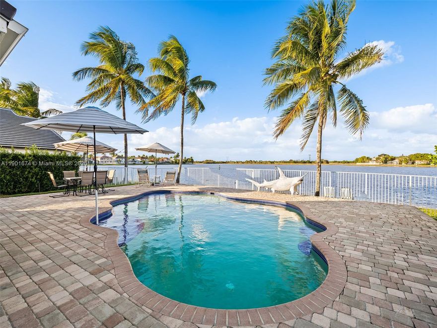 Welcome to this beautifully maintained and thoughtfully updated home, showcasing true pride of ownership. With over 3,400 total sqft, this spacious 5-bed, 3.5-bath residence offers a formal living and dining room, plus a separate family room—all with expansive lake views.The updated kitchen features 42” cherry wood cabinets, granite counters, a Sub-Zero fridge, and KitchenAid appliances, perfectly positioned to overlook the serene backyard, pool, and lake.Upgrades include FULL impact windows and doors (plus accordion shutters), a brand new roof (2024), and a newer AC unit. The fully fenced backyard is an entertainer’s dream with a saltwater pool and built-in outdoor kitchen. Located in the gated community of The Falls and zoned for A++ schools—this is the home you’ve been waiting for!