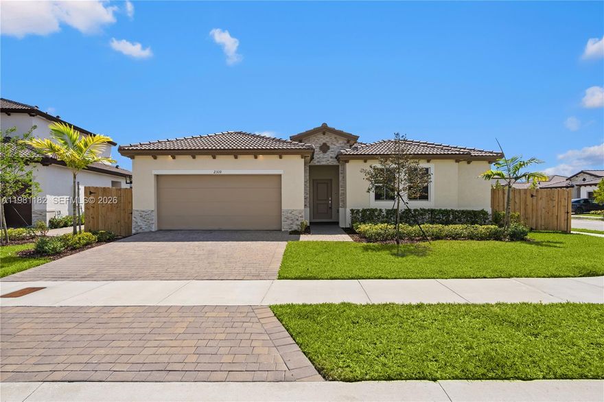 Beautiful single story home in the sought after Malaga collection at Altamira in Homestead, featuring a private attached guest suite with its own entrance, living area, kitchenette, bedroom, bathroom, and laundry, ideal for extended family, guests, or flexible living. The main home offers formal living and dining areas, an open concept kitchen with center island, Shaker style cabinetry, stainless steel appliances, and seamless flow into the family room for comfortable everyday living and entertaining. The spacious primary suite provides a peaceful retreat with tray ceiling, large walk in closet, and spa inspired bath with dual sinks and full width vanity. Two additional bedrooms are privately set along a separate hallway. Mediterranean style exterior with stone accents and architectural detailing. Located in the Altamira master planned community with resort style amenities including clubhouse, fitness center, restaurant and bar, golf pro shop, ballroom, business center, pool, tennis courts, BBQ area, golf course, and parks. Conveniently near shopping, dining, entertainment, Homestead Speedway, and Keys Gate Tennis Club.