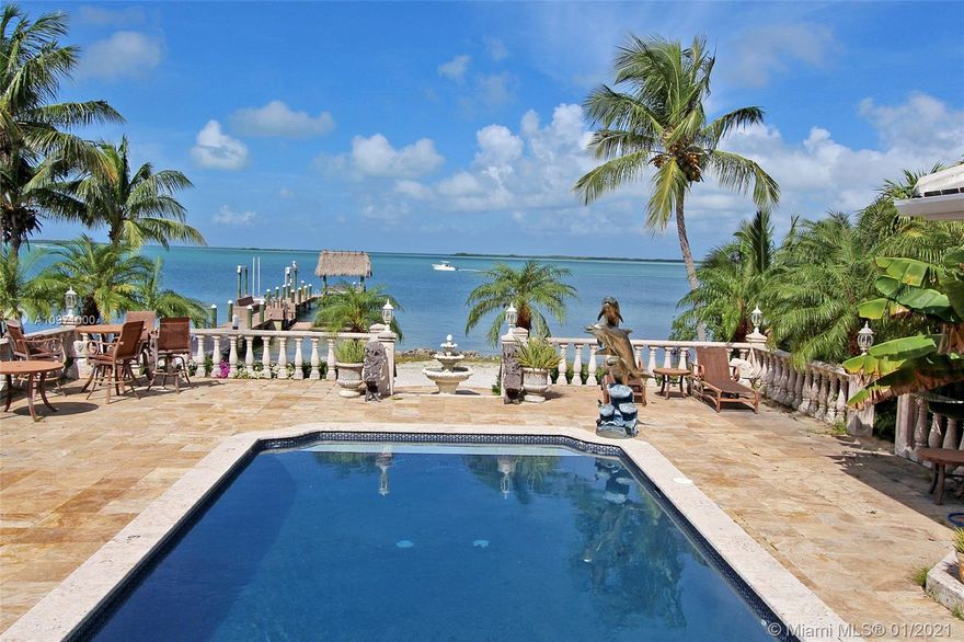 Sandy Beach, Sunsets & Dockage! Privately-gated open bayfront estate with sandy walk-in barefoot beach AND dockage with 16K lb. four-point boat lift plus a relaxing tiki hut platform at the end! Enjoy magnificent sunsets from this elegant ground level home designed so you can walk right out of the living room and into the pool (no stairs!) and enjoy the outdoor kitchen/bar and pizza oven by the pool. There's also a high-end kitchen with gas cooktop, a separate 1/1 guest house, a 3-car garage and a private electric gate and winding driveway. Another unique feature is a an open bayview owners suite with two separate bathrooms (one with a walk-in closet, shower and spa tub, and one with a sauna and shower).