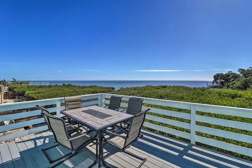 Welcome to your slice of paradise in Marathon, where island living meets exceptional investment potential. Tucked at the end of a quiet street in mid-town, this upgraded property captures sweeping Atlantic Ocean views and boasts a strong short-term rental history - ideal as both a private retreat and income-producing asset. Expansive parking accommodates boats, multiple vehicles, RVs, and even an EV charging station, a rare find in the Keys. Lush landscaping with palms, raised garden beds, and automated irrigation creates a true tropical oasis with effortless upkeep. Inside, the updated kitchen features new appliances (2021), a stylish island, refreshed countertops and backsplash, and a functional pantry, perfect for entertaining. Thoughtful upgrades include Spanish tile work, blackout shades, updated ceiling fans, and refinished custom woodwork. Enjoy ocean views from the primary suite’s walk-in shower or unwind in the jetted whirlpool tub. Designed for both durability and efficiency, the home includes hurricane-impact windows and doors, upgraded insulation, a new central air system (2021) with A/C compressor (2026), refurbished roof (2021), a dryer duct fan, and numerous system upgrades. Outdoor living shines with a wraparound porch, outdoor shower, privacy wall, and garden shed. Whether you're seeking a full-time residence, vacation escape, or high-performing rental, this Marathon gem delivers on lifestyle, function, and location.