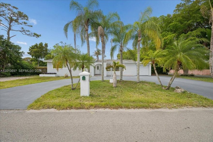 Step into refined South Florida living in this beautifully updated residence nestled on an expansive lot with a private detached guest house/in-law quarters, offering the perfect blend of elegance, comfort, and versatility. From the moment you arrive, the grand circular driveway, mature palm trees, and sleek modern exterior create an unforgettable first impression.

Inside, discover bright and airy interiors featuring oversized living spaces, soaring ceilings, abundant natural light, and a seamless open-concept layout designed for both sophisticated entertaining and everyday luxury. The spacious kitchen opens effortlessly to the main living areas and offers ample cabinetry, generous prep space, and an inviting flow ideal for gatherings.

The primary suite provides a peaceful retreat with vaulted ceilings, oversized closet space, and a beautifully appointed bath. Additional bedrooms are generously sized and thoughtfully designed for comfort and functionality.

One of the property’s most exceptional features is the detached guest house, perfect for extended family, guests, a private office, gym, or income-producing potential. The sprawling backyard offers endless possibilities to create your dream outdoor oasis with room for a pool, summer kitchen, and more.