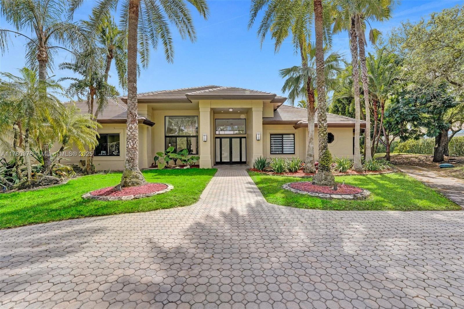 An ultra-private 1.5-acre estate with nearly 200 feet of water frontage in Windmill Ranch Estates, Weston’s premier gated enclave. This property features a 5BD/6BA main home plus a 1BD/1BA guest house with full kitchen. Recent updates include a new roof, partial impact windows and doors, circular driveway, and fresh paint. The main house offers an open layout with a grand kitchen, large island, and family room with fireplace. Two primary suites with spa-style baths. HVAC updated in 2024 (guest) and 2019 (main). Fully fenced yard with 6-zone irrigation and space for a pool or court.