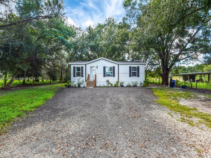 Located just outside the heart of LaBelle, this newly built 2024 manufactured home offers 3 bedrooms and 2 bathrooms on a spacious one-acre lot. The interior is bright and inviting with modern laminate floors and an open kitchen featuring bar seating and contemporary cabinetry. Step outside to enjoy peaceful evenings on the patio overlooking mature trees and a private, wooded backdrop. The property is dotted with fruit trees and provides plenty of room for outdoor activities, gardening, or simply relaxing in the quiet setting. With simple, low-maintenance landscaping and a perfect blend of modern design and rural charm, this home is an ideal retreat for anyone seeking the comfort of new construction in a tranquil country atmosphere.