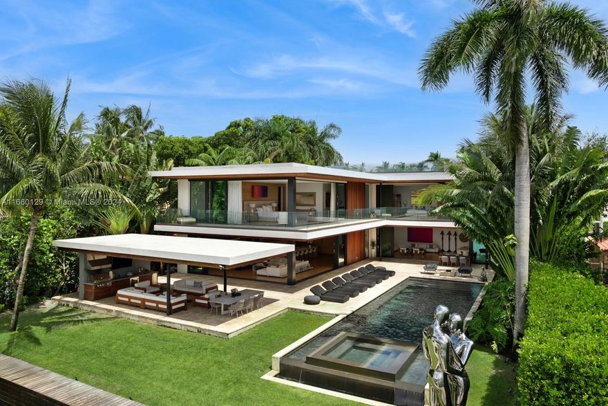This Venetian Islands modern mansion has it all: Downtown views, Sunsets, incredible interiors, a lot & a half + 90 feet of water frontage. Three distinct social areas benefit from skyline exposure enhanced by 10’ telescopic windows. An integrated wood-paneled kitchen + oversized pantry complete the gourmet experience. The oak flooring on the main level leads upstairs where the picturesque Primary has it all: 2 closets, drench shower, deep soaking tub, book-matched marble, and an enviable view. The tropical pool, spa, cabana + Summer kitchen, ample green space, dockage for multiple boats & jet skis, and rooftop complete the outdoors. Draped in ipe and coral stone, a privacy gate and 2 car garage enhance the first appeal. Plus theatre, office, gas cooking, Jr. Primary, & spacious terraces.