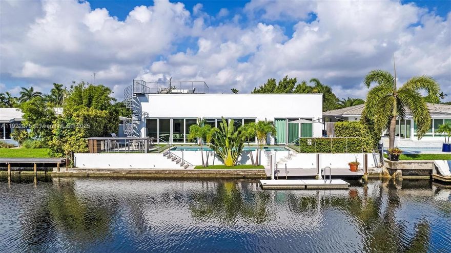 Hidden behind a majestic century tree, this Wilton Manors waterfront masterpiece delivers an unforgettable “wow” the moment you step inside. Turnkey and fully furnished if desired, this 4 bedroom, 4 full bathroom contemporary home, giving you instant cash flow from day one. Soaring 9+ ft ceilings, an open floor plan and gigantic hurricane-impact sliding glass walls span the entire width of the house, framing unobstructed water views and flooding every room with natural light. The result is a powerful sense of nature flowing through the home—sky, palms and canal reflections feel like part of your living room.  

Outside, a brand-new, fully equipped summer kitchen, sparkling pool and floating boat dock create the ultimate waterfront playground, making it easy to host unforgettable gatherings or launch your boat, paddleboard or kayak in minutes. Above it all, a spectacular rooftop terrace offers 360-degree, no-obstruction views for magical sunsets, moonlit dinners and stargazing—your private sky lounge. This rare property blends lifestyle, privacy and leveraged income into one high-vibration opportunity: a luxury, furniture-optional, income-producing retreat that attracts clicks online and emotions in person, perfect for investors, second-home buyers and anyone ready to upgrade into effortless, abundant South Florida living. EASY TO SHOW