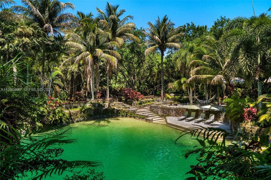 Breezy Oaks is a rare 14.38-acre tropical farm oasis in the Redlands featuring a private Florida Rock Pine Preserve. This one-of-a-kind sanctuary blends natural beauty, privacy, and endless potential. A dramatic entrance with massive coral rock pillars and custom copper gates leads to a winding coral rock-lined driveway and a 3BR/3BA surrounded by mature oaks and lush tropical landscaping. The property’s centerpiece is three freshwater coral rock grottos sourced from the Florida aquifer, masterfully crafted by renowned artisan Ben Bistrong. These extraordinary features include cascading waterfalls, sandy beach areas, a hidden cave, and tranquil swimming pools—creating a truly resort-like setting unlike anything else in South Florida. Expansive open lawns, winding paths, and a 3-acre rock pine preserve provide space for recreation, large-scale entertaining, or future customization and development. A thriving fruit grove with mango, avocado, and citrus trees, along with an on-site bee colony producing fresh honey, enhances the property’s organic, self-sustaining appeal. An elevated pad grass area for a 6-stall barn on the Southwest corner plus a substantial storage structure with dedicated access provides added utility and flexibility. Ideally located near the Florida Turnpike with easy access to Miami, Homestead, and the Florida Keys. An additional 29.20 acres are available for a combined 43.58-acre opportunity.