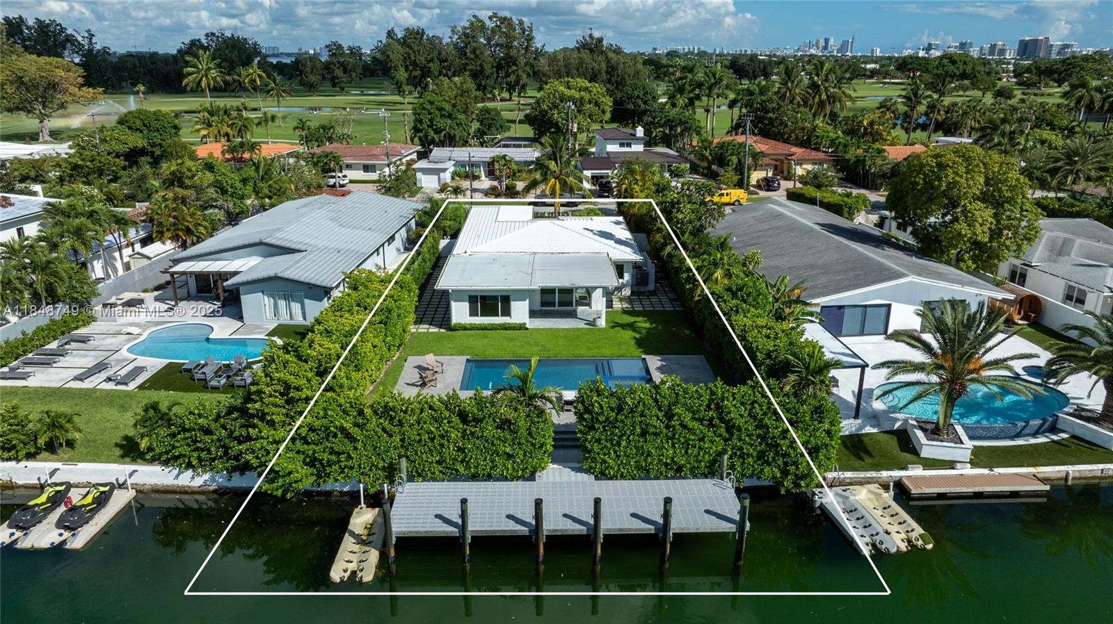 Beautifully renovated waterfront residence on the exclusive, gated Normandy Shores Island. This 2,854-square-foot home offers 4 bedrooms and 3 baths, with a modern open floor plan. The large living room flows seamlessly into a gourmet kitchen fully equipped with top-of-the-line appliances and custom finishes throughout. Additional features include a laundry area under AC with 4 washers and dryers, a garage under AC, and much more. The expansive outdoor space is perfect for entertaining, featuring a covered dining area, an oversized pool with a jacuzzi, a new dock to accommodate both a boat and a jet ski, breathtaking water views, all surrounded by a lush tropical garden.