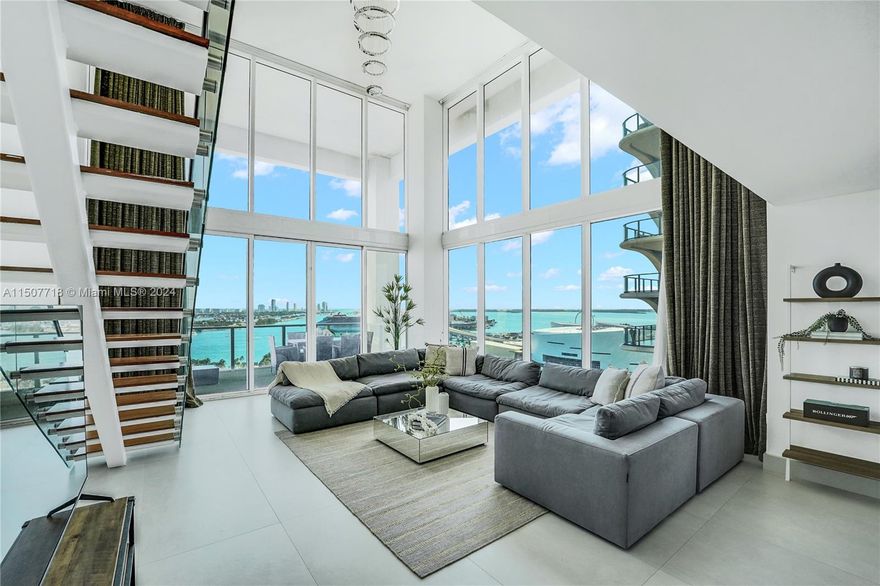 Immerse yourself in Chad Oppenheim’s iconic Ten Museum Park. This pristine two story loft is newly renovated with all-new ceramic tiles, Porcelanosa bathrooms, backlit,marble cocktail bar,solid wood doors, designer lighting fixtures, floating staircase with glass railings, Bosch ACs, Miele appliances, and automated curtains. These SE corner units are rarely on the market. No developments will ever obstruct the stunning panoramic views from its 20ft windows and huge terrace! Condo comes with two parking spaces and large storage unit. AMENITIES galore: 20,000 square foot spa, sauna, fitness center, 24 hour security, & valet!. Enjoy amazing views from multiple pools, PLUS EXCLUSIVE MEMBERSHIP TO THE BENTLEY BEACH CLUB ON 1ST AND OCEAN DR!!!  Building is majority owner-occupied. MUST SEE!!!