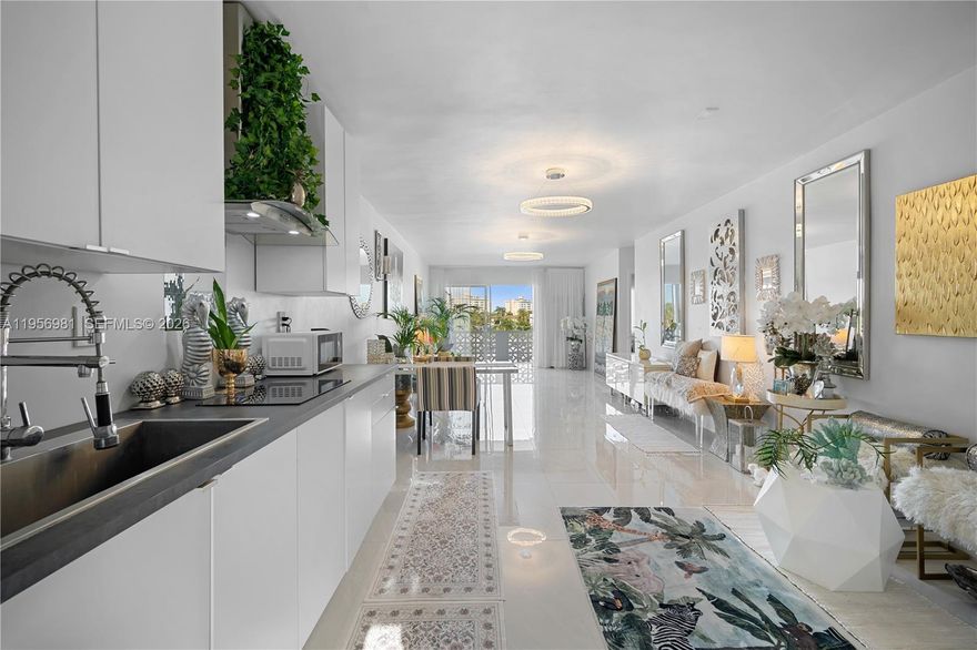 Step into this beautifully updated condo offering a bright, open-concept layout designed for modern living. You’re welcomed by glossy porcelain floors, sleek lighting fixtures, and a spacious living and dining area that flows effortlessly to a private balcony with serene city, greenery, and water views.
The modern kitchen features white cabinetry, stainless-steel appliances, a stylish range hood, and countertop space—ideal for everyday cooking and entertaining. The bright and spacious bedroom is designed for comfort and relaxation, easily accommodating a king-size bed, nightstands, and additional seating or storage. Large windows flood the space with natural light. Located in a charming garden-style, catwalk building with only four floors, this residence offers a more intimate, low-density living experience. Residents enjoy a beautiful pool area tucked away in the back, perfect for relaxing and unwinding. With its open layout, refined finishes, and inviting atmosphere, this home offers the perfect balance of style, functionality, and comfort. Seller is extremely motivated and ready to make a deal—priced aggressively and open to all reasonable offers. Rental permitted after one year of ownership. Ideally located near Oleta River State Park, Bal Harbour, Haulover Beach, local restaurants, shopping, and schools. Easy to show—schedule your private tour today before it’s gone.