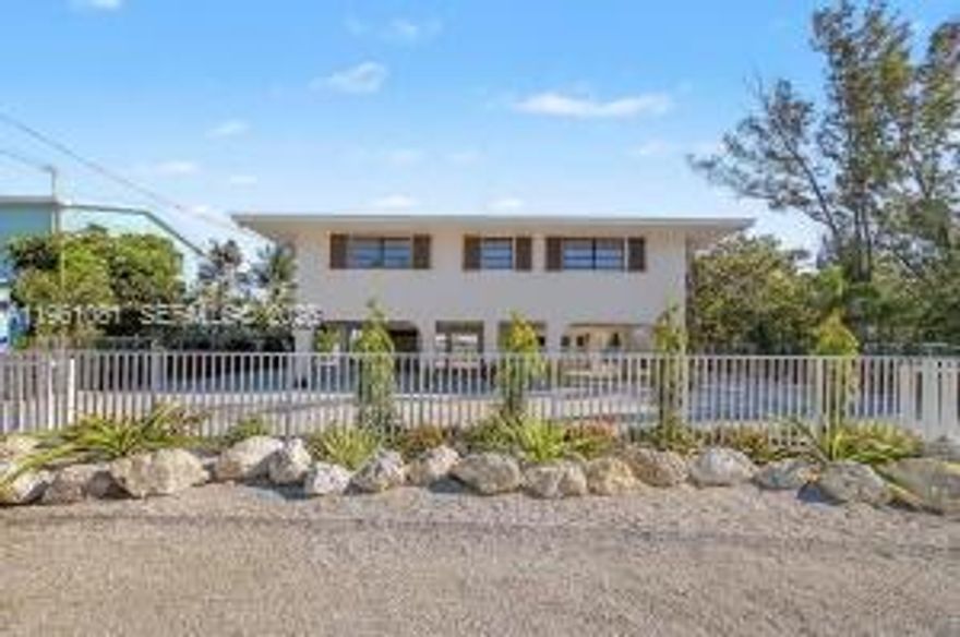 Privacy is a rare luxury, and this home delivers it with peaceful, soul-soothing views that instantly make you exhale. Perched on sturdy stilts, this 2-bedroom, 2-bath retreat sits in a quiet, tucked-away neighborhood overlooking the shimmering Gulf of America. Built Solid with CBS concrete construction and a metal hip roof that gives you confidence, while the open floor plan and oversized screened porch invite you to slow down and savor the scenery. A newly installed lift adds to a everyday convenience, and the remodeled kitchen and bathrooms bring fresh style to the home's warm, light-filled interior. Tile floors throughout keep things cool and easy to maintain. Step outside to more than 8,000 square feet of lush, with an aluminum fenced yard—plenty of room for your water toys, gardening dreams, or simply stretching out under the palms. Launch your kayak, paddleboard, or canoe right from your private floating dock and explore the calm waters at your doorstep. This is a rare gem where comfort meets coastal serenity. Welcome home to views that make you say...WOW.