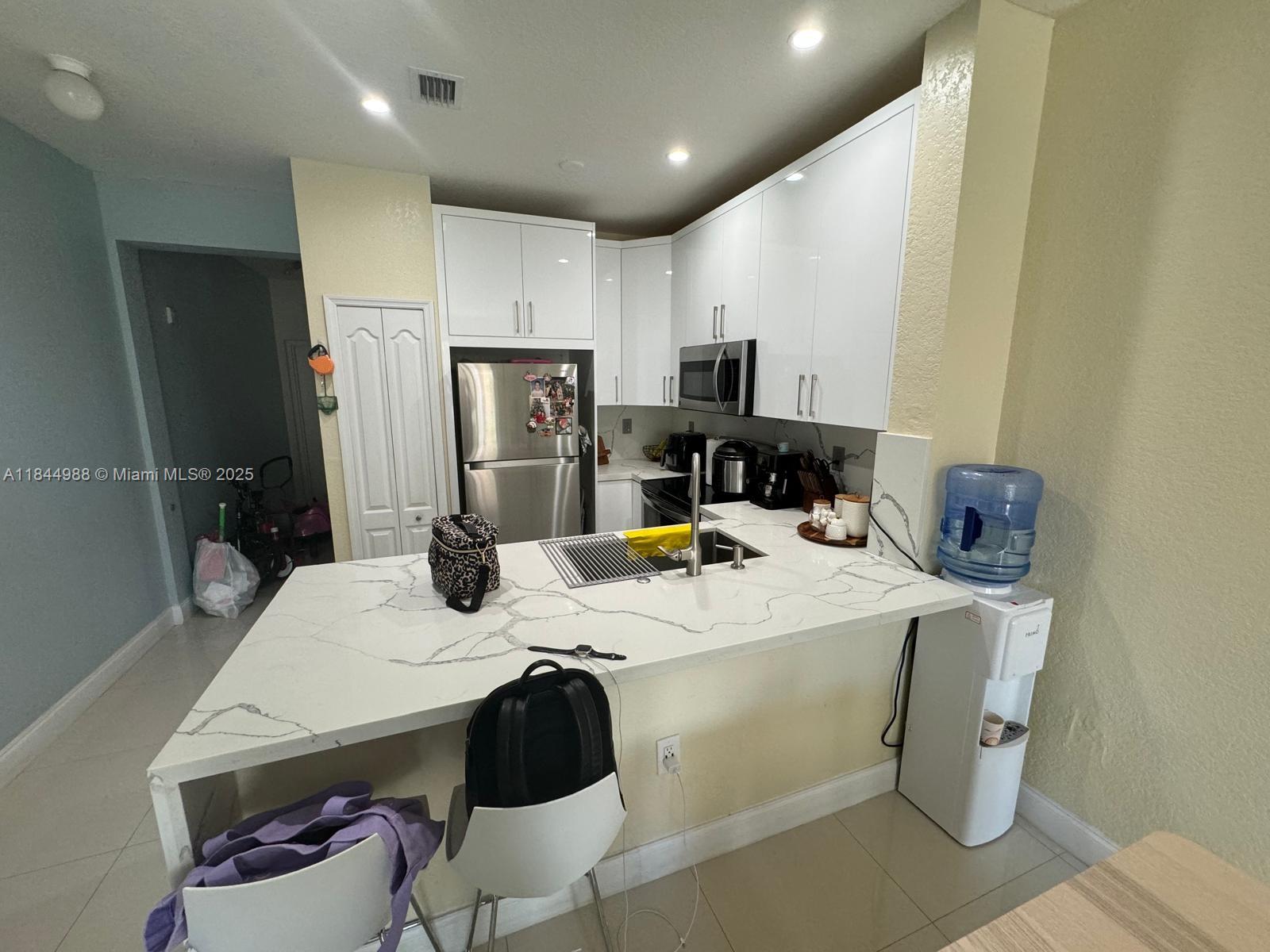 Beautiful second-floor condo unit at Shoma Homes Country Club, two-bedroom, two and half-bathrooms. AVAILABLE ( SEPTEMBER 2025) Located in the desirable Hialeah/Miami Lakes area, this property offers a spacious layout with large bedrooms, ample closet space, and an open-concept kitchen. Features include tiled, new laminate flooring throughout bedrooms, and carpet in the staircase, in-unit washer and dryer. Access to a clubhouse and community pool. Enjoy the convenience of an assigned parking space, and plenty of guest parking.