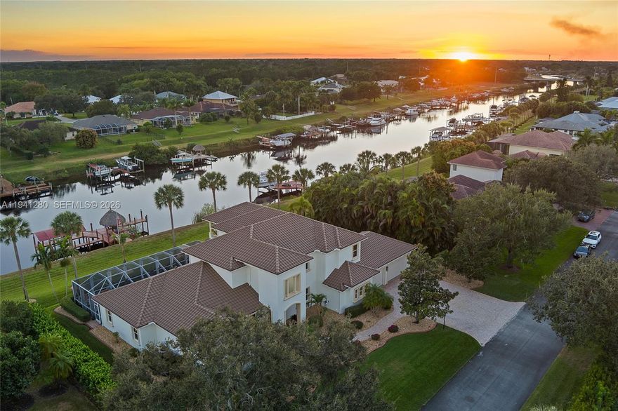 Welcome to your own private paradise in the heart of Port St. Lucie. This stunning custom Mediterranean-style CBS estate offers the ultimate in luxury waterfront living with over 150 feet of frontage along the C-24 Canal. Designed for boating enthusiasts & entertainers alike, the property features a private dock with boat lift, a tiki hut perfect for sunset gatherings, & quick access to the nearby public boat ramp. This five-bedroom, five-bath residence offers an exceptional floor plan with a first-floor guest suite, home office, family room, dry bar, balcony, residential elevator, & a three-car garage, all thoughtfully designed for comfort, functionality, & elevated Florida living. A screened pool & spa create a true resort-style outdoor retreat, complemented by a summer kitchen with grilling station, cabana bath, fire-pit area, & lush tropical landscaping. Inside, soaring ceilings & travertine floors set the tone for refined living. The chef’s kitchen features dual sinks, dishwashers, ovens, refrigerators, an eight-burner gas cooktop, granite countertops, wine coolers, icemaker, & generous prep space. The primary suite offers dual walk-in closets, a sitting area, & a spa-inspired bath. Additional highlights include impact windows & doors, Taylor foam wall insulation, Icynene ceiling insulation, surround sound, & central vacuum. Located in the gated enclave of South River Shores with low HOA fees, minutes to the Turnpike, shopping, dining, & Tradition.