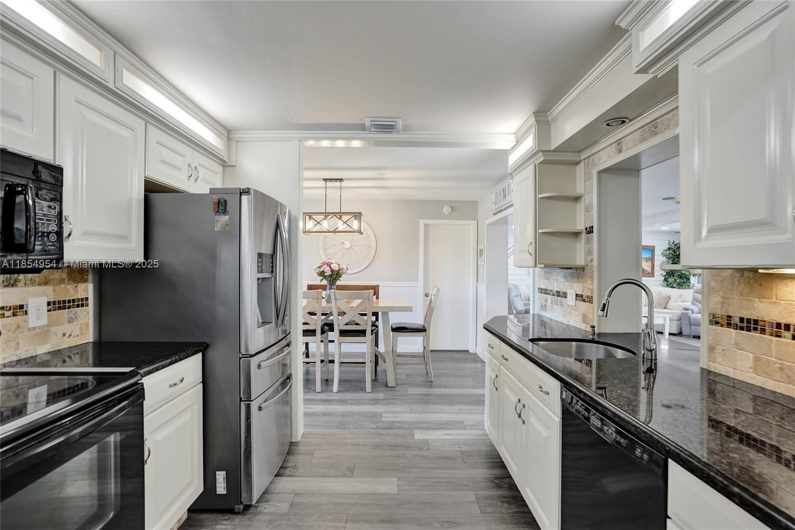 Spacious Gorgeous 2BD/2BA + Garage & BONUSROOM easily used as 3rd BR in 55+ Paradise Gardens Sec 3. Recently remodeled gourmet kitchen w/SS appliances opens to formal dining—perfect for entertaining family & friends. Home offers vinyl floors, separate family & formal living rooms, tastefully remodeled bathrooms, COMPLETE impact windows/doors & newer Roof (2018). Spacious Florida room overlooks lush landscaping & tranquil water view. Rare privately fenced yard (grandfathered), uncommon in this community. Steps to clubhouse, pool, gym, shuffleboard & more. Low HOA covers lawn care & exterior paint. HOA requires a minimum credit score of 700. Active, well-maintained community near shops, dining, hospitals, highways & just minutes to the beach—ideal for low-maintenance South Florida living!