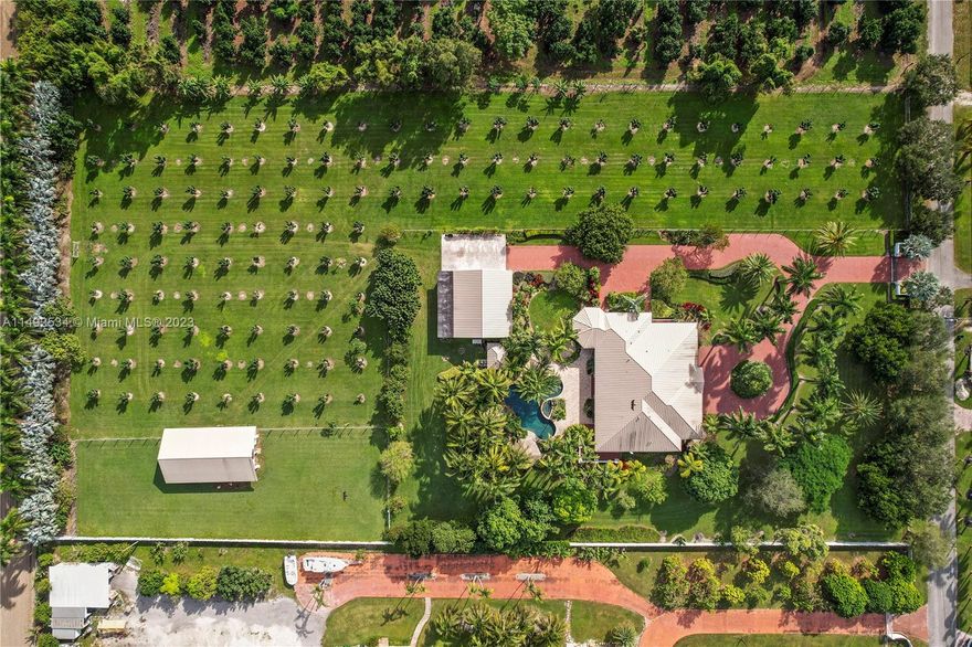 Located in Redland, Miami Dade's Agriculture community, sits a custom 2009 gentleman's 5 acre country estate with a tropical flair. She's a big girl with 9000 sq. ft. under roof and 5500 under air, tastefully appointed, designed & built to last generations. No detail was spared on this 4/5 w/ bonus room (current use is an office). The suites & living areas open onto 230 linear ft veranda that wraps around this beauty and provides space for the chef's summer kitchen/bar with impact W & D allowing the beauty of the outside in. Additional exterior features include a detached finished a/c garage w 2nd level, a water treatment sys, 48kw generator w 1000lb propane, irrigated longan grove w asst tropical fruit for personal use, barn w/ storage & loft. fenced and cross fenced. security in place