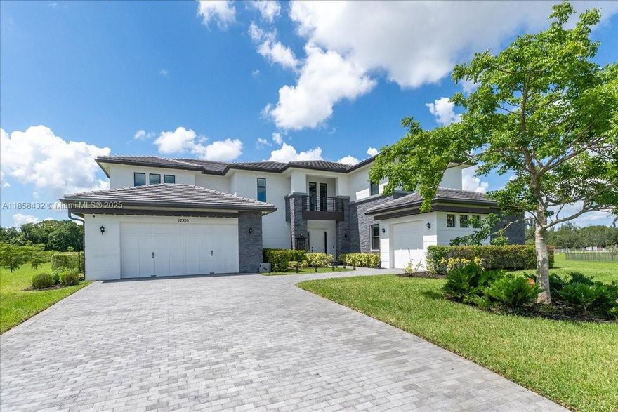 Stunning 2019-built estate in coveted Rolling Oaks, Southwest Ranches. Set on a 2-acre cul-de-sac lot, this 5BR/5.5BA home offers a well-designed floor plan with beautiful finishes. First floor features an office, master suite with 2 custom closets, luxe bath with jacuzzi, rain shower & jets, plus an additional bedroom suite. Spacious living area boasts a gourmet kitchen with Jenn-Air appliances, double ovens, quartz island, huge walk-in pantry & bar with wine/beverage fridges & quartz counters. Upstairs: 3 bedrooms & loft. Expansive fenced yard showcases a beach-entry pool, spa & swim-up bar—perfect for entertaining.