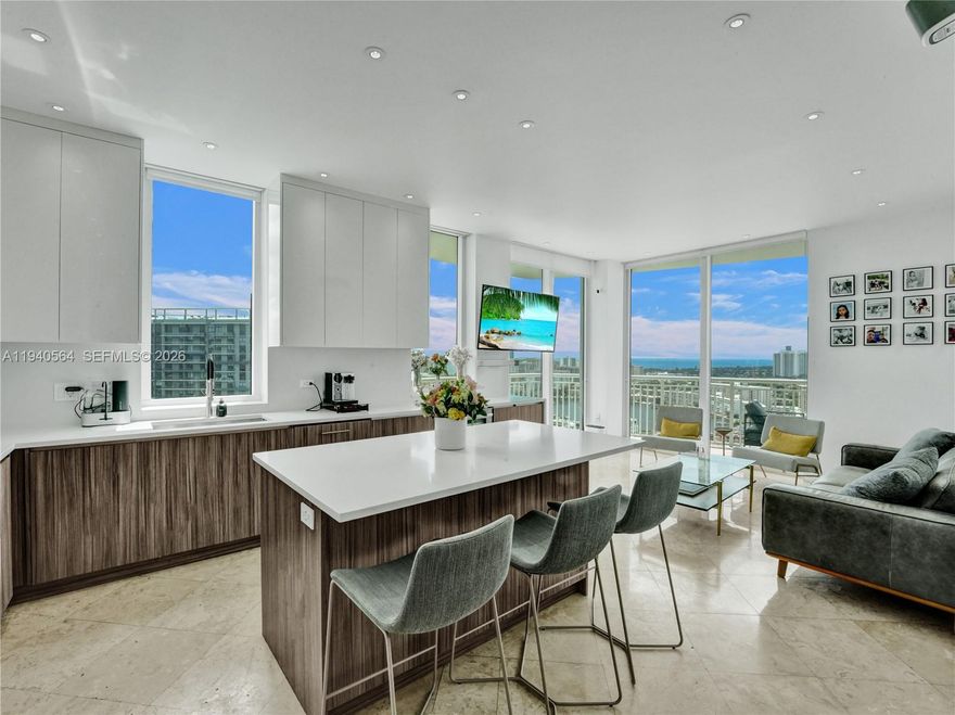 Extremely rare opportunity to acquire the most prestigious residence in the building. This expansive 3-bedroom, 3.5-bath home offers over 1,700 square feet of impeccably designed living space. Fully renovated, the unit showcases breathtaking ocean and city skyline views, elegant travertine flooring throughout, and a seamless open-concept layout ideal for modern living.

The gourmet kitchen features custom Italian cabinetry and top-of-the-line appliances, flowing effortlessly into the living and dining areas. Soaring 10-foot ceilings, LED recessed lighting, and exceptional natural light enhance the home’s refined ambiance.

A truly one-of-a-kind highlight is the expansive 180-degree oversized wraparound terrace, offering abundant space for outdoor lounging and entertaining.

Building amenities include an outdoor pool, fitness center with sauna and steam room, tennis court, garage and valet parking. The residence includes three parking spaces and is ideally located within close proximity to premier shopping, dining, and the beach.