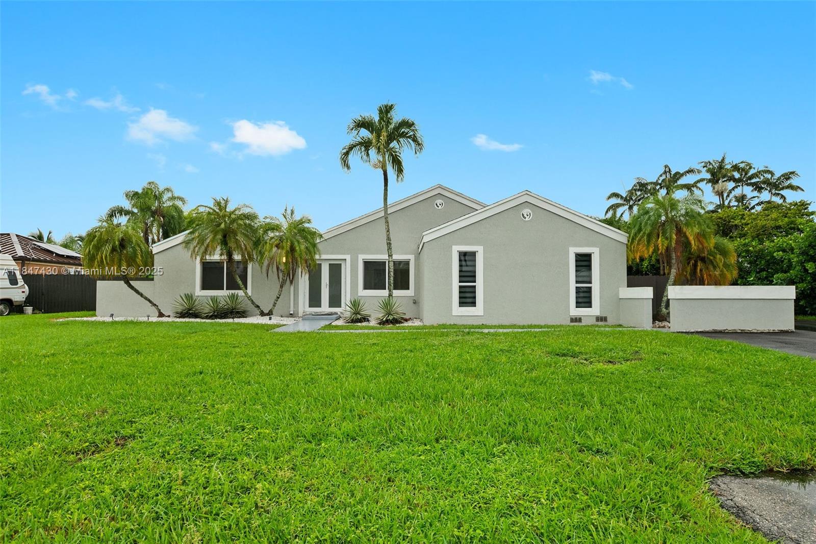 Beautifully updated 5BR/2BA home on a spacious 12,500 sq ft lot in peaceful neighborhood. This gem features fully renovated bathrooms with modern finishes, a stylish kitchen with quartz countertops and stainless steel appliances, and gorgeous oversized tile flooring throughout. The open layout offers multiple living areas perfect for entertaining. Step outside to a tropical oasis with a covered patio, lush landscaping, and a sparkling swimming pool. Enjoy privacy, space, and comfort with impact windows, a 2-car garage, and plenty of room for outdoor fun. Located near great schools, shopping, and dining — this home has it all!