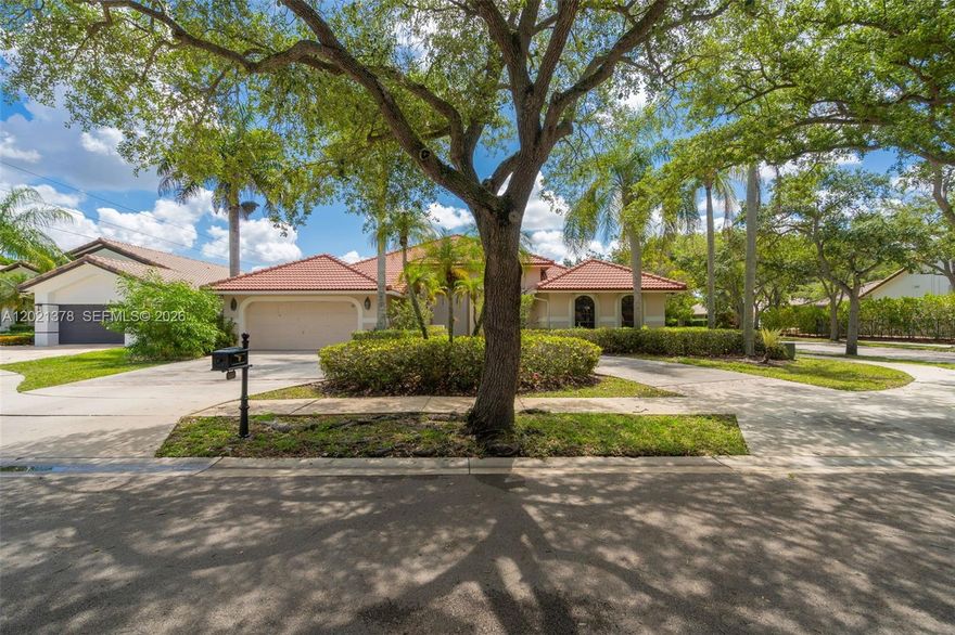 Welcome to this stunning one-story home in Tequesta at Country Isles, one of Weston's most exclusive guard-gated communities. Set on a 12,391 SF lot, this impressive 5-bedroom, 3-bathroom residence offers 3,449 SF of total space with soaring volume ceilings, abundant natural light, and a seamless open floor plan. The gourmet kitchen is a chef's dream featuring dark granite countertops, custom wood cabinetry to the ceiling, a large center island with cooktop, stainless steel appliances including a double oven, and a stunning mosaic tile backsplash. The expansive living and dining areas flow effortlessly through sliding glass doors to the screened pool and covered patio perfect for entertaining year-round. Large-format porcelain tile floors and a dramatic natural stone accent wall add a sophisticated touch throughout. Mature tropical landscaping, a paver driveway, and a tile roof complete the picture. Top-rated A+ schools, minutes from Weston Town Center, dining, shopping, and I-75.