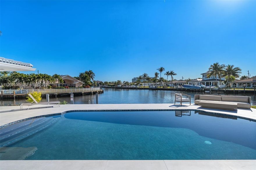 Fully renovated modern waterfront residence in Pompano Beach offering over 110 feet of waterfront with ocean access via one fixed bridge at Federal Hwy, approximately 14’ clearance at low tide. Designed for seamless indoor-outdoor living, the home showcases expansive glass, clean architectural lines, and a striking contemporary kitchen overlooking the canal. An oversized waterfall island anchors the space, complemented by high-end appliances, smooth Level 5 drywall, and redesigned drop-down ceilings that create a crisp, gallery-like finish throughout. Walls of glass open to a resurfaced pool and wide water views from the primary suite, with generous dockage potential along the full 110 feet of frontage. Ideal for boaters seeking protected dockage with convenient access. Major improvements include a 2020 roof, a newer AC system, upgraded electrical, and updated plumbing, offering true peace of mind beyond cosmetic enhancements. Structurally improved and thoughtfully renovated, this residence is built for a refined South Florida waterfront lifestyle in a prime Pompano Beach location.