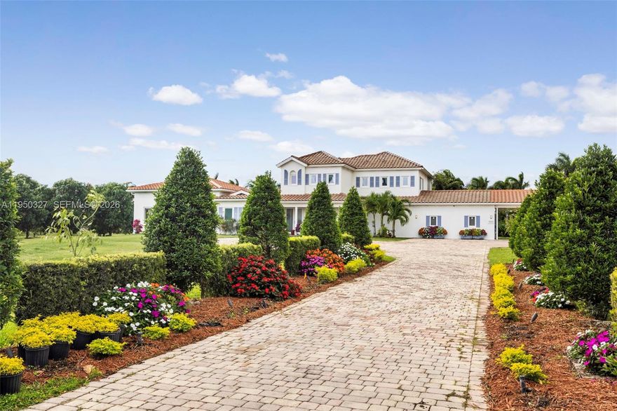 Gated estate set on 5 acres in Savannah Ranches featuring a compound-style layout with main residence and connecting guest house. Over 6k sqft of living space. Main home features 4 bedrooms and 4.5 baths, including an expansive primary suite spanning over 1,000 SF, along with a theater, expansive kitchen, and generous living areas. Outdoor amenities include a pool, beautifully manicured grounds, art studio and a coral rock koi pond. The property is enhanced with mature fruit trees including avocado, mango, longan, starfruit, mamey, sapodilla, cherry, sugar apple, lychee, and coffee fruit, providing year-round harvests.