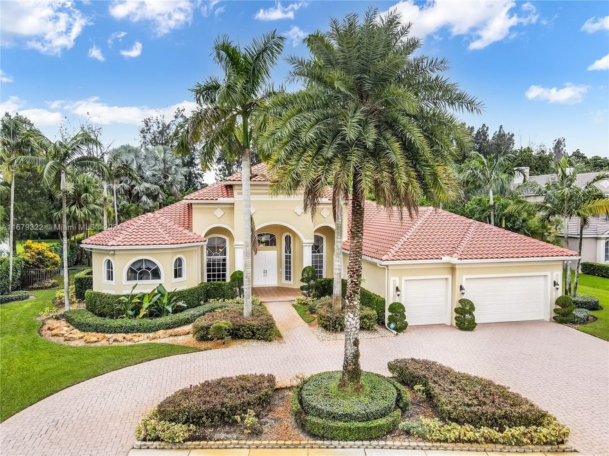 Welcome to this exquisite custom-built home on a builder’s acre in the prestigious gated community of Stonebrook Estates. This luxurious residence features a grand foyer leading into formal living and dining areas, and a gourmet kitchen with a wet bar. Enjoy coffered ceilings, expansive picture windows, and custom doors that flood the space with natural light. The split floor plan offers a lavish primary ensuite with a sitting area, dual closets, and a spa bath. Spacious bedrooms with one serving as a home gym with cabana bath and separate entrance. Step outside to a private fenced backyard with a swimming pool, grotto waterfalls, a pool slide, caves, and tropical landscaping. Host gatherings in the covered outdoor summer kitchen and relax on the deck while enjoying views of lush greenery.