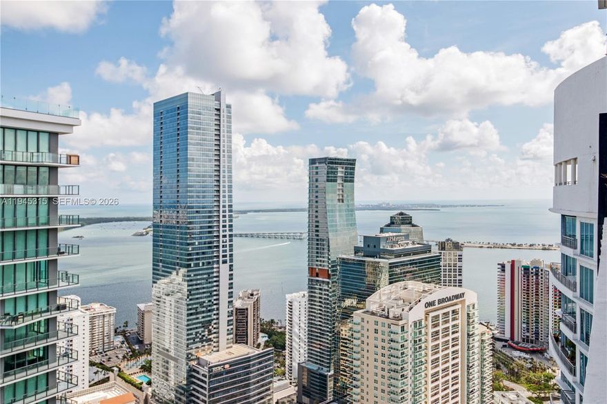 Live in luxury on the 50th floor - this lower-penthouse level is the highest available floor in the building, and one of the highest views available in Brickell under $700,000.   The star of the show is the double-height living room (over 20 feet) framing iconic skyline + water views.  Floor to ceiling + wall to wall glass flood the condo with light and vistas to enjoy.   Real wood floors and floating staircase leads to the bedroom level.   Entertain outside on two private oversized terraces that run the length of the condo.    You can start your day in this outdoor extension to your family room with yoga, coffee and your laptop.  The 2nd floor has two bedrooms partially open to 1st floor  . You will see how the second bedroom is currently set up as the ultimate home office!  Electric black-out shades, built-out closets, 2.5 updated spa baths add to your comofort. One self-park garage space, available valet, big  gym, heated pool, hot tub, pool, doorman, security. Steps away from Brickell, Mary Brickell Village, Publix, gyms and cafes.   The location speaks for itself, easy access to highways, supermarkets, fine dining, fitness options and local parks.   Established and secure building with no drama.   24 hour notice, month to month tenant with 45 day kickout.