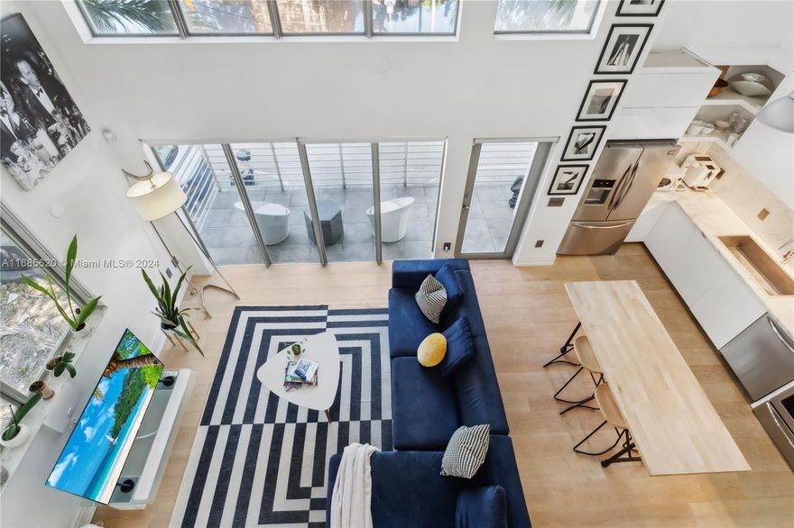 Priced to Sell.   South of Fifth Loft with soaring 20ft double-height ceilings, light wood floors, and floor-to-ceiling impact windows, offering an abundance of natural light.   Bright primary suite on the upper level of the loft,  the second bedroom is on the main level, both with sliding shades for privacy.  Expansive floor layout with balcony, Beautiful Boffi kitchen, stainless steel appliances, washer and dryer in-unit, and upgraded bathrooms.  Building amenities include an outdoor pool, elevator, covered and gated parking space, and a secure lobby    Sought after south of fifth neighborhood.  Walk to the beach or fabulous restaurants, cafes, boutique shopping. Condo docs. Seller Disclosure and Structural integrity report in attachments