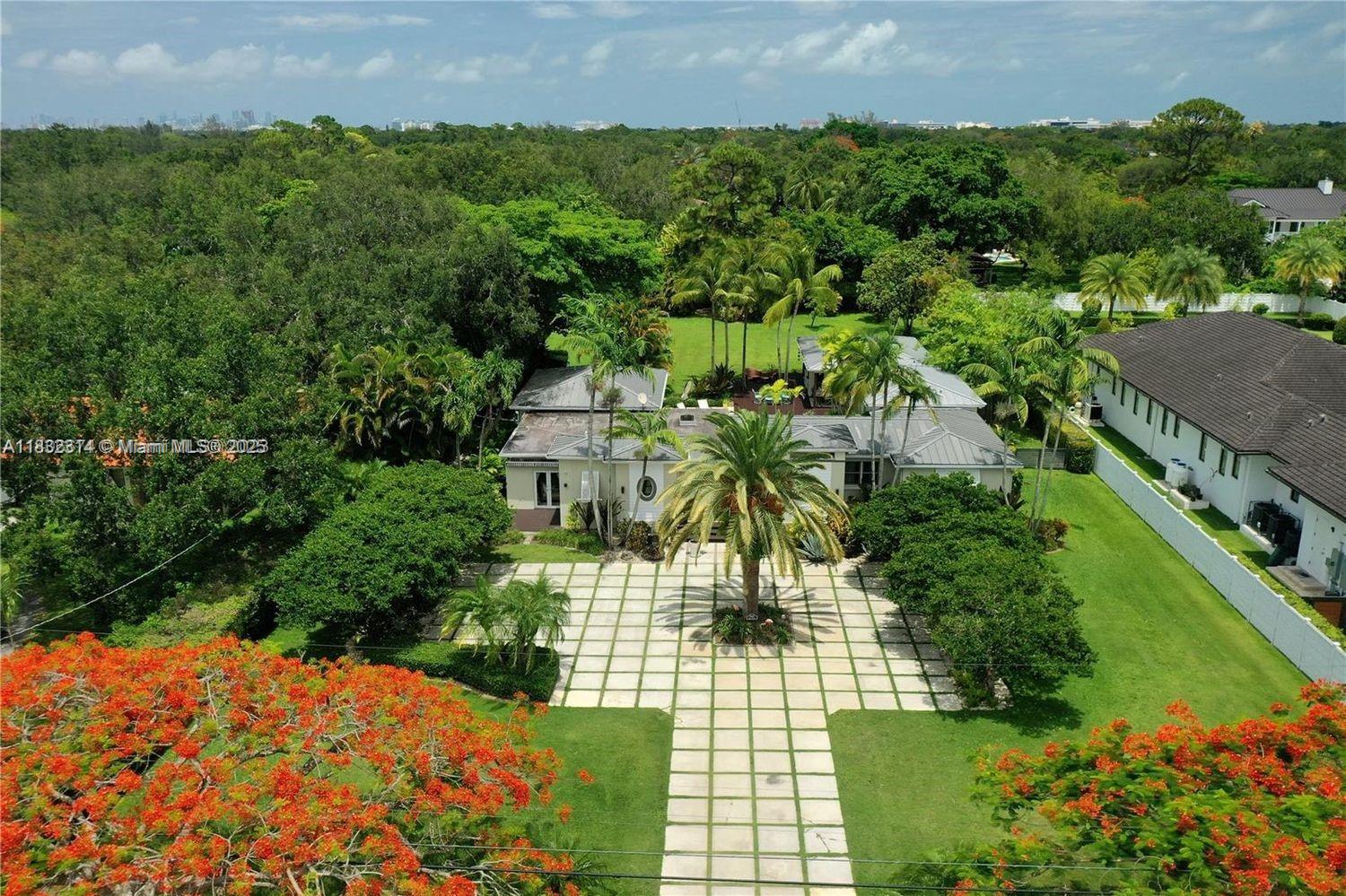 Discover your own private retreat in this tropical, resort-style property set on a builder's acre with lush, mature landscaping. The sunlit main house offers open-concept living, 4 bedrooms, and 3.5 baths, including a stylish primary suite tucked away in its own wing for ultimate privacy. Across the lagoon-style pool and expansive deck, a separate pool house provides flexible space for guests, an in-law suite, or a home office. Outdoor living shines with a covered terrace, outdoor shower, and generous backyard - perfect for soccer, gatherings, or enjoying fresh tropical fruit from your own trees. Additional features include an EV charger, storage shed, ample gated parking, and top-rated schools nearby. Offered partially furnished.