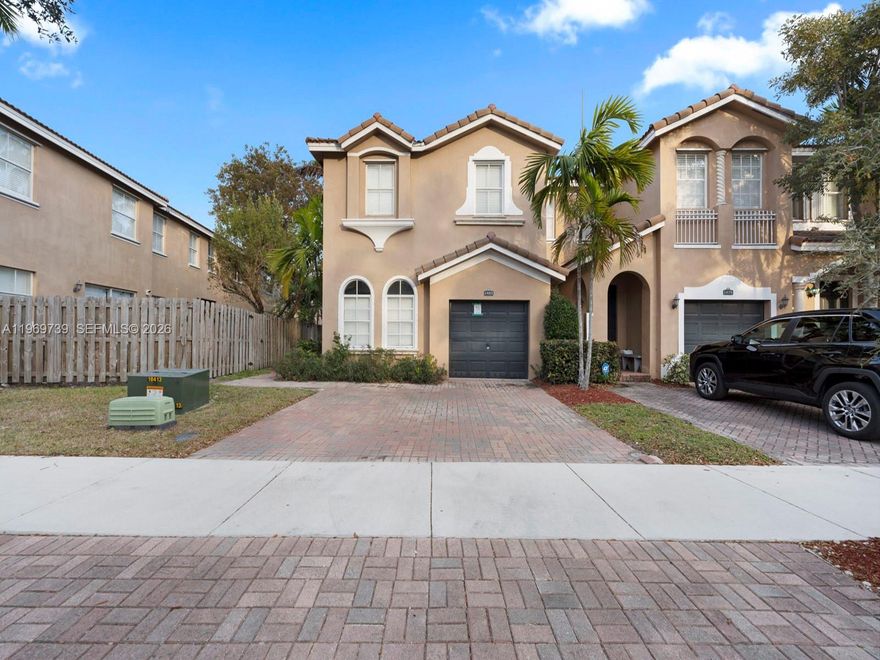 Welcome home to this spacious, move-in-ready CORNER townhouse featuring 4 bedrooms, 3 bathrooms, and an attached single-car garage. Boasting excellent curb appeal with a charming brick paver driveway and Mediterranean-inspired architectural details, this home is bathed in abundant natural light. Step inside to discover a bright, open-concept main floor tailored with easy-care tile flooring and elegant arched accents. The kitchen features warm wood cabinetry, sleek black appliances, a convenient pantry, and a breakfast bar that flows seamlessly into the designated dining and living areas. 

Double sliding glass doors open directly to your private, fully fenced backyard—perfect for weekend barbecues, relaxing, or letting pets roam. With its freshly painted neutral palette and inviting layout, this fantastic corner unit is a true blank canvas waiting for your personal touch.  

Low HOA fees include cable and internet - no approvals required.