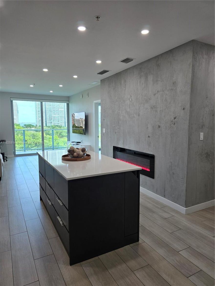 This contemporary one-bedroom, one-bathroom residence offers a light and airy atmosphere with an open Italian kitchen and living room, perfectly blending indoor and outdoor living. Enjoy exceptional views of lush green space, sparkling water, and the stunning skyline, all enhanced by meticulous design and soaring 10-foot ceilings with tall windows and sliding glass doors.
The custom kitchen features elegant stone countertops and upgraded appliances. The home boasts ceramic tile flooring throughout and a luxurious bathroom. For added convenience, there is a dedicated laundry area equipped with a full-size washer and dryer.
Residents will appreciate the lobby and arrival experience designed by Ligne Roset, as well as access to a fitness center, a rooftop pool, and other premium amenities.