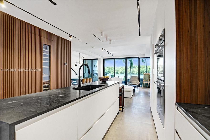 ASSUMABLE MORTGAGE at a 2.875% interest rate with an approximate remaining balance of $550,000! This is not a remodel—it’s a full architectural reinvention taken down to the studs and rebuilt with intention. Located on exclusive Poinciana Island, this residence offers unobstructed Intracoastal views overlooking the Oleta River and Oleta River State Park, delivering rare water-and-greenery privacy. Over $500,000 in high-end renovations include a $65K Mia Cucina kitchen, panel-ready Thermador appliances with dual-temp wine refrigeration, custom stone counters and sinks, and $60K in bespoke millwork by Obscure Design featuring a hidden powder room, integrated bar, custom storage, and elevated primary bath design. The floor plan was completely re-engineered with wider pathways, increased storage, floating stairs, and a fourth convertible bedroom/den. Additional upgrades include French oak hardwood floors, spa-style primary bath with touch-control steam shower, custom lighting, full smart-home infrastructure, and electronic window treatments. Property includes approved permits and plans for a private deeded boat dock, a mudroom with separate entrance, and a second-floor bedroom terrace adding future square footage and outdoor living. Thoughtfully designed, smart, and future-ready.