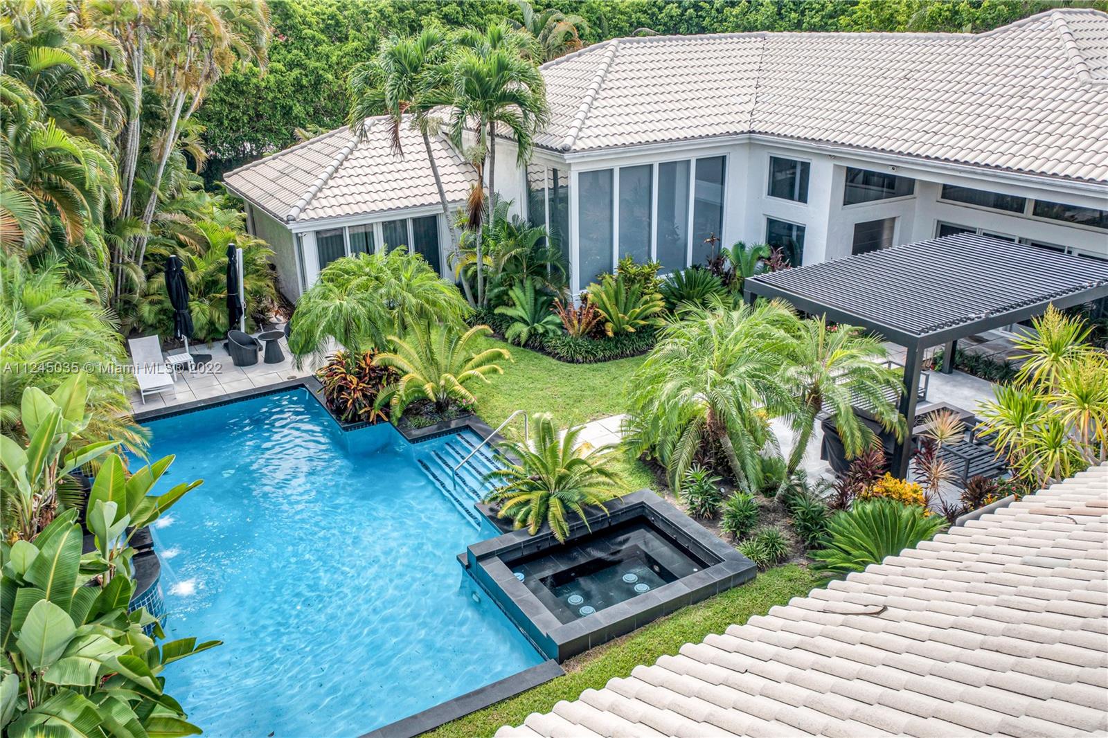 An Oasis awaits in the sought after community of Broken Sound. This stunning estate sits on over a half acre & is adorned with only the finest finishes. Step in from the imported pivoting steel doors to the lush green wonderland that embraces the pool/patio area. Another pivot leads you into the home where you are immediately taken by the soaring ceilings, open layout & natural light that cascades in through the floor to ceiling impact windows. The main house offers 3 oversized en suite bedrooms with custom finishes. Kitchen is fitted with state-of-the-art Gaggenau appliances overlooking a huge family room. Cross the patio to a beautiful pool-front guest house complete with living area, large bedroom & bathroom.  Other features include 3-car garage, laundry room, imported marble, & atrium.