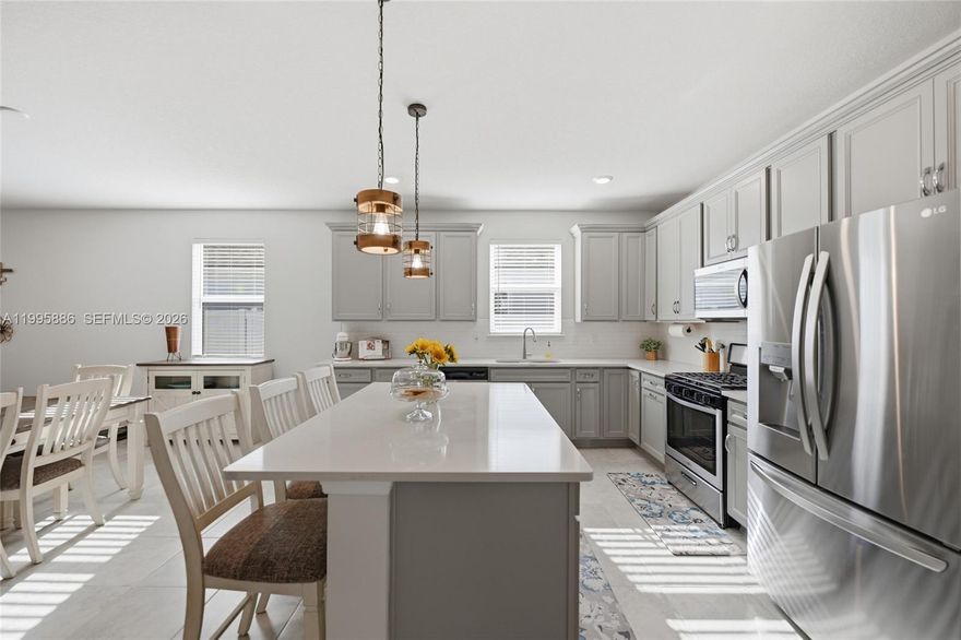 where scenic water views, wooded preserves, and everyday convenience come together. Designed with both style and functionality in mind, this award-winning floor plan offers a bright, open-concept layout with 3 spacious bedrooms, 2 full bathrooms, and a versatile flex room perfectly positioned to capture tranquil water views--ideal for a home office, playroom, or additional living space. Soaring 9-foot ceilings and thoughtfully selected finishes create an inviting, modern feel throughout. At the heart of the home, the chef-inspired kitchen is built for both entertaining and daily living, featuring quartz countertops, an oversized island with pendant lighting, 42'' cabinetry with soft-close doors and double roll-out drawers, stainless steel appliances, a large pantry, and the added benefit of natural gas. The spacious great room flows seamlessly to an enclosed lanai through triple sliding glass doors, extending your living space outdoors. Enjoy peaceful mornings or evening gatherings while overlooking a private backyard with a unique combination of white vinyl and aluminum fencing--perfectly framing serene preserve views. The primary suite offers a relaxing retreat with a large walk-in closet, dual vanities, a garden tub, and a separate shower. Beyond the home, Bradley Pond offers a lifestyle that's hard to match--featuring five scenic ponds, a playground, walking and hiking trails, and a kayak launch into Clapboard Creek for outdoor enthusiasts.