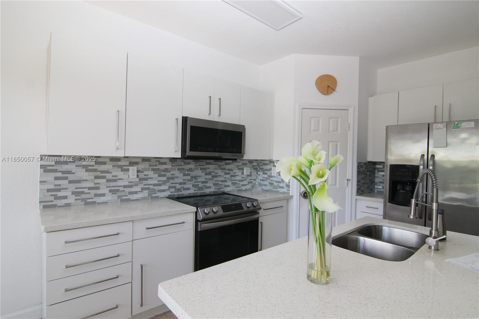 Live in this spacious 4 bedroom 3 bathroom townhome 1 car garage with a double driveway in Doral's Sonoma, the gated community with guard at gate and 24 hour security patrol. Enter the living room with high ceilings, continue to the bedroom and bathroom on the first floor, then go to the kitchen with stainless steel appliances, granite countertops, backsplash and food pantry. Enjoy the sunlight coming through the floor to ceiling sliding doors illuminating the kitchen. Open the sliding doors to its very own enclosed patio and enjoy this area. Continue to the second floor to the 3 bedrooms and 2 bathrooms. Washer and Dryer. The entire townhouse is freshly painted. This townhome has a water softener equipment. Sonoma has a children play area. The entrance of Sonoma is on SW 114th Avenue.