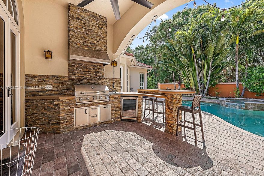 Impeccably maintained and truly inviting, this custom 5 bed, 5 bath home features a separate office and club room, offering the perfect layout for both everyday living and entertaining. The chef's kitchen boasts SubZero refrigeration, Thermador gas cooktop, double ovens, and built-in ice maker, opening to a warm great room and a stunning outdoor kitchen with custom grill/bar and extended covered patio. The fenced yard features lush tropical landscaping, turf grass, and a resurfaced heated saltwater pool and spa—an outdoor oasis. Solid 8 ft doors, custom fireplace, updated ACs, hurricane impact windows, and a new roof (2019) provide comfort and peace of mind. Ideally located near beaches, Downtown Abacoa, top schools, shopping, dining, golf, and boating—everything Jupiter has to offer!